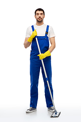 Image showing male cleaner in overal cleaning floor with mop