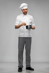 Image showing male chef in toque with saucepan cooking food