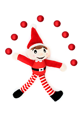 Image showing Christmas Elf Juggling Fun with Red Bauble Ball Decorations