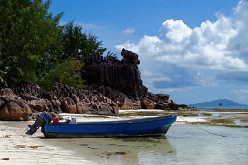 Image showing Motor boat at the beach on Curieuse Island, Seychelles, with lava stone rocks and lush vegetation