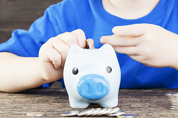 Image showing boy lays in his piggy bank