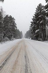 Image showing a dirty, broken snow-covered road