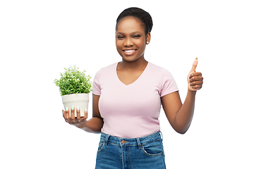 Image showing happy african woman with flower showing thumbs up