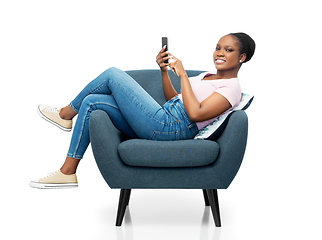 Image showing african american woman with smartphone in armchair