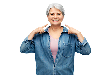 Image showing smiling senior woman showing to her face