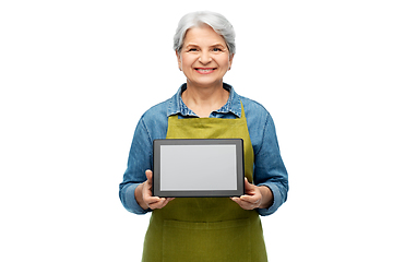 Image showing happy senior woman in garden apron with tablet pc