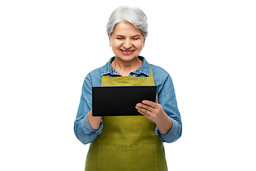 Image showing happy senior woman in garden apron with tablet pc