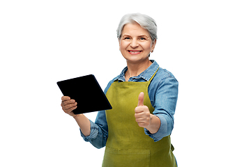 Image showing happy senior woman in garden apron with tablet pc