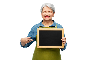 Image showing happy senior woman in garden apron with chalkboard