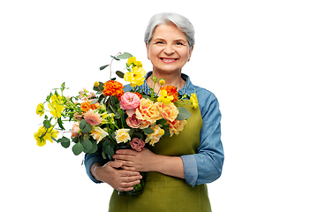 Image showing smiling senior woman in garden apron with flowers