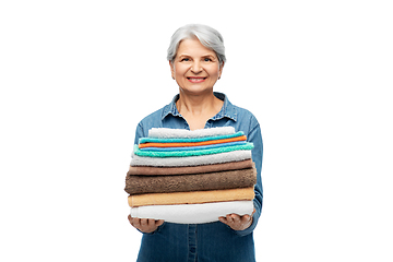 Image showing smiling senior woman with clean bath towels