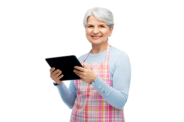 Image showing smiling senior woman in apron with tablet computer