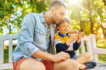 Image showing father and son with smartphone at park