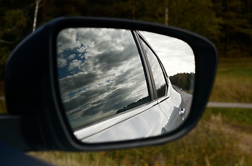 Image showing clouds are reflected in the car's rearview mirror