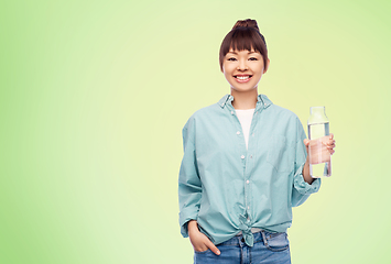 Image showing happy asian woman holding glass bottle with water