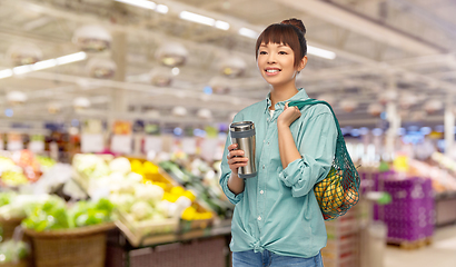 Image showing woman with thermo cup or tumbler for hot drinks