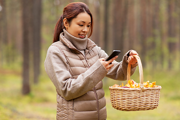 Image showing asian woman using smartphone to identify mushroom