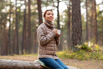 Image showing asian woman with mug drinking tea in forest