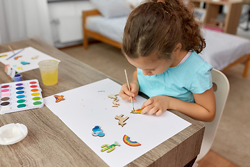 Image showing little girl painting wooden items at home