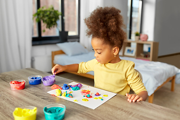 Image showing little girl with modeling clay playing at home