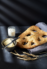 Image showing close up of cheese bread, butter, knife and milk