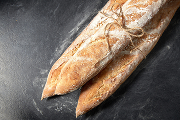 Image showing pile of baguette bread loaves tied with rope