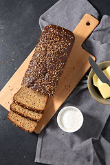 Image showing close up of bread, butter, knife and salt on towel