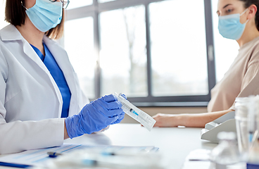 Image showing female doctor with syringe and patient at hospital