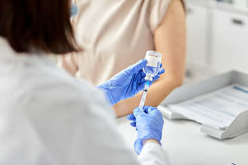 Image showing female doctor with syringe vaccinating patient