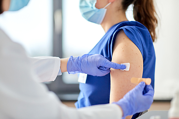 Image showing doctor attaching patch to medical worker