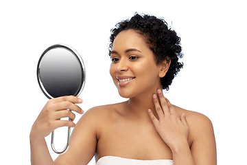 Image showing smiling african american woman looking to mirror