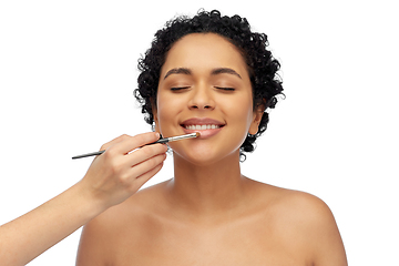 Image showing happy woman and hand of make up artist with brush