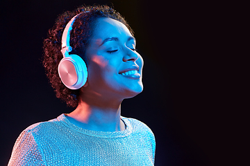 Image showing woman in headphones listening to music and dancing