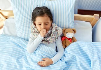 Image showing sick coughing girl with teddy bear lying in bed
