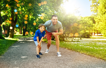 Image showing happy father and son compete in running at park