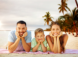 Image showing happy family lying over tropical beach background