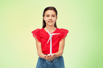 Image showing smiling girl with toy wind turbine over green