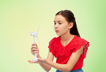 Image showing smiling girl with toy wind turbine over green