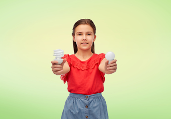 Image showing smiling girl comparing different light bulbs