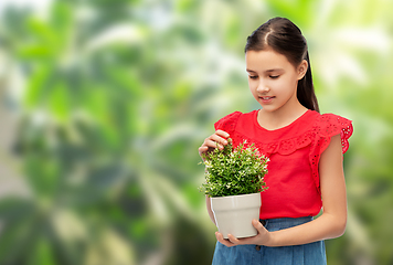 Image showing happy smiling girl holding green flower in pot