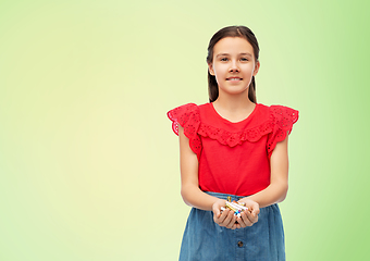 Image showing smiling girl holding pile of alkaline batteries