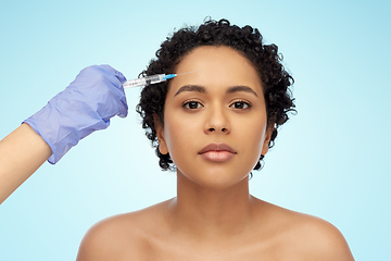 Image showing face of african woman and hand with syringe