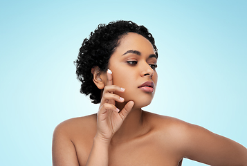 Image showing young african american woman with moisturizer