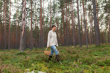 Image showing woman with basket picking mushrooms in forest