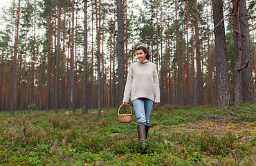 Image showing woman with basket picking mushrooms in forest