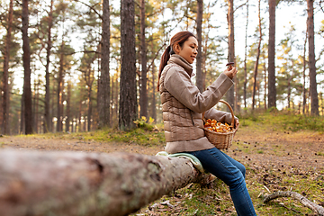 Image showing woman with mushrooms in basket in autumn forest