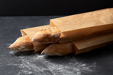 Image showing close up of baguette bread in paper bags on table