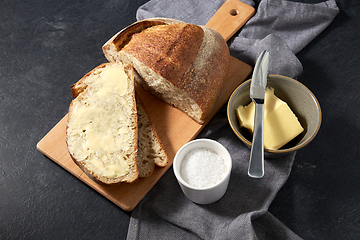 Image showing close up of bread, butter, knife and salt on towel