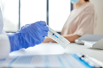 Image showing female doctor with syringe and patient at hospital