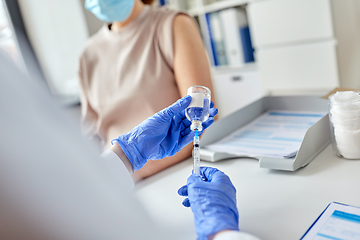 Image showing female doctor with syringe vaccinating patient